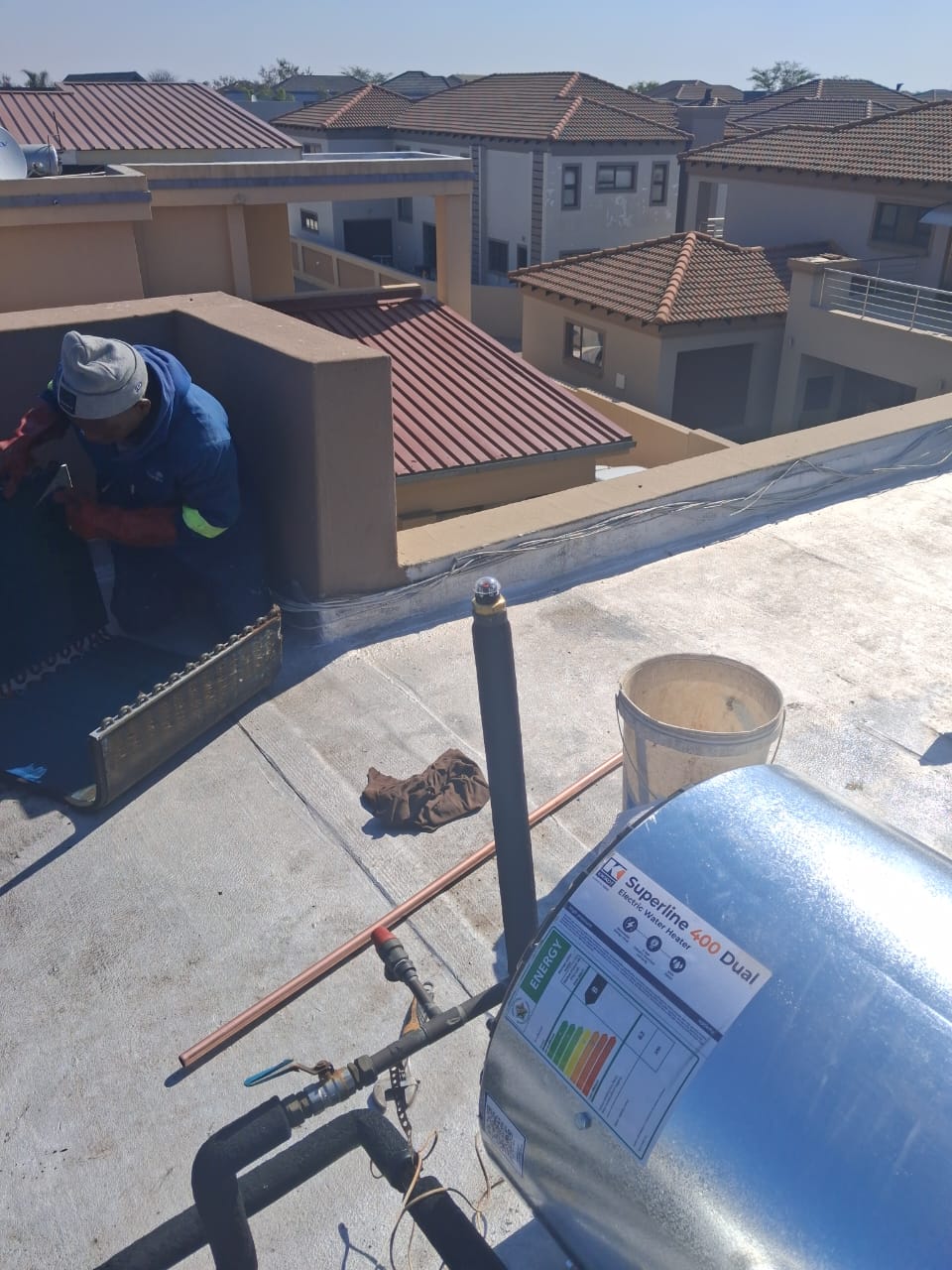 Plumber installing a rooftop geyser on a Gauteng estate