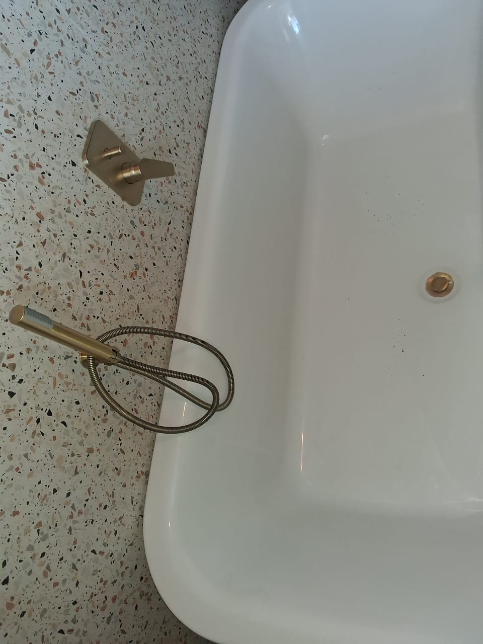 Freestanding bath from above with brushed-gold hand shower