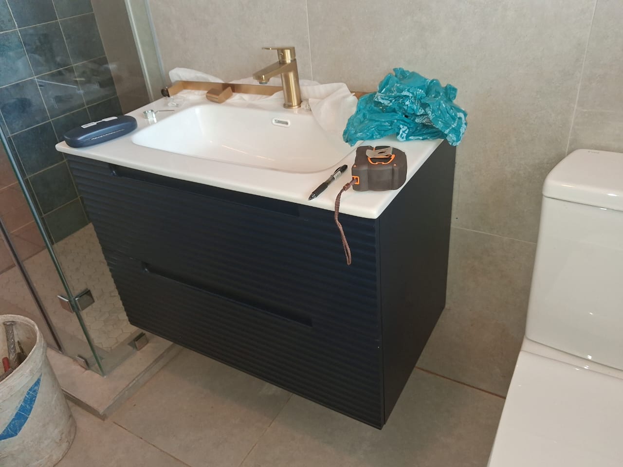 Navy vanity and basin, angled view with tools on counter
