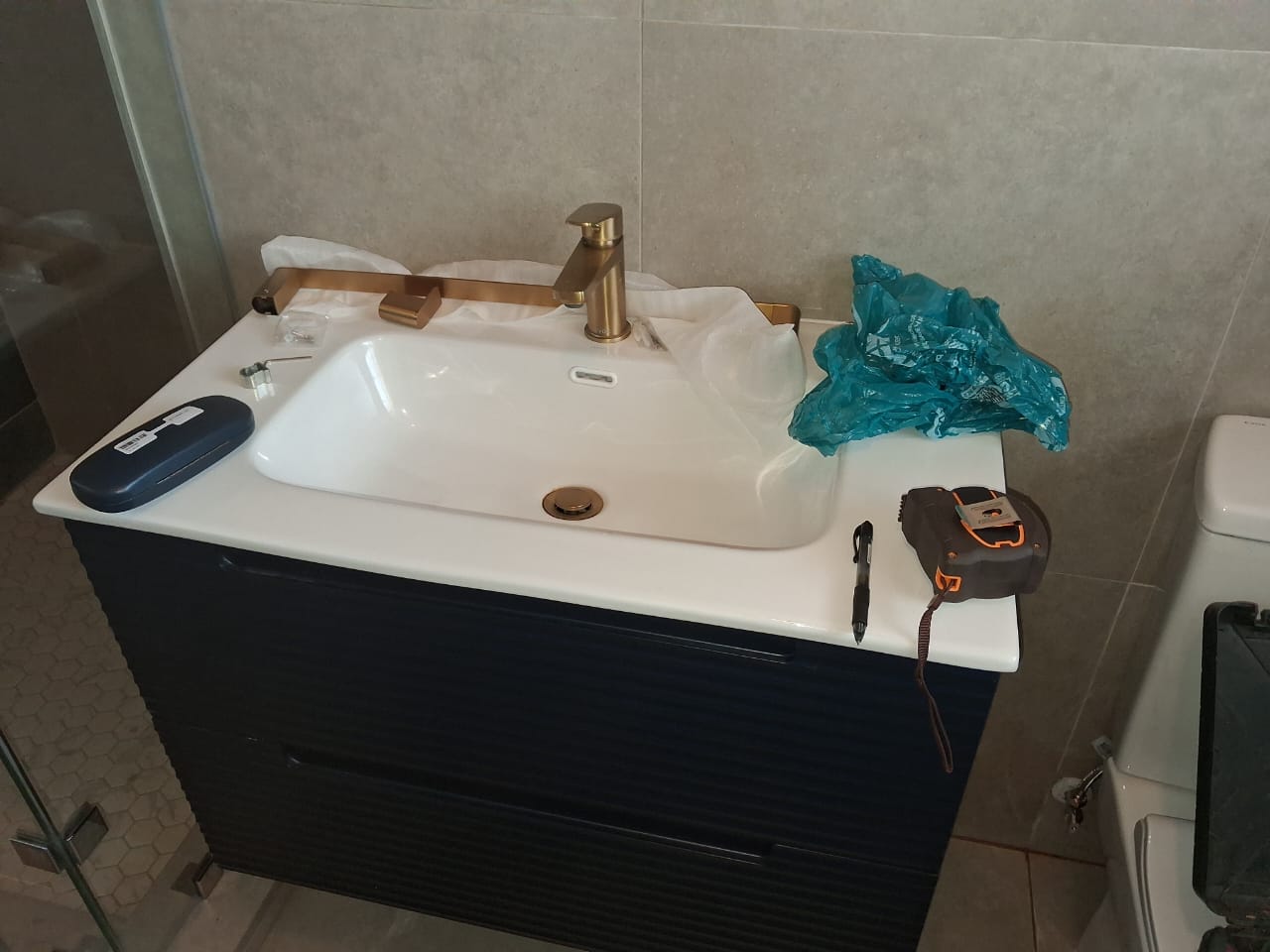 Navy vanity with basin, wide view during install